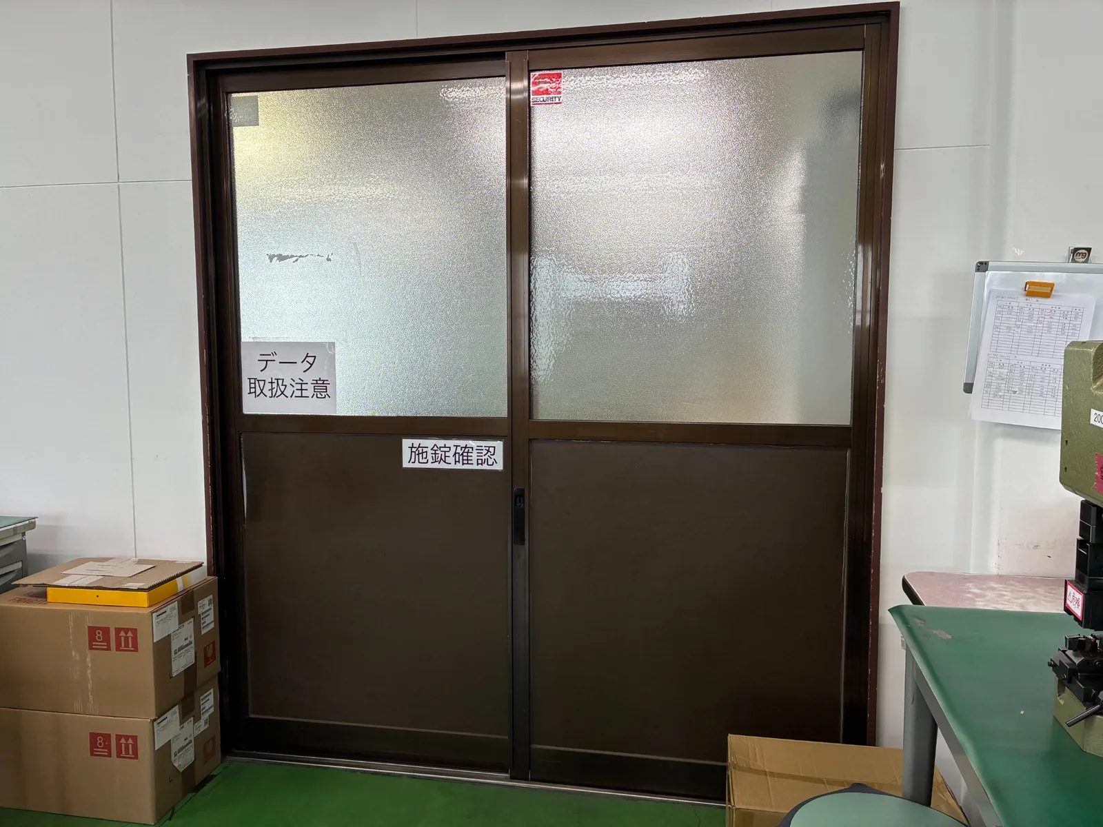 データ取扱注意と施錠確認の表示があるPC作業場所