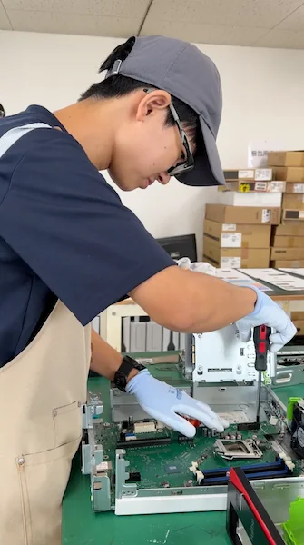 パソコン内部を確認しながら整備作業を行う様子